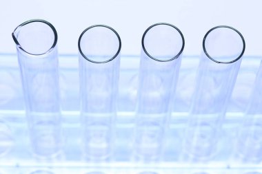 Mavi Plastik Şeffaf Stantta Cam Tüplü Boş Laboratuvar Grubu, Stüdyo beyaz arka plan aydınlatma, izole edilmiş kopya alanı, yakın çekim