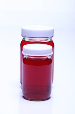 Kırmızı Sıvı, iki şişe beyaz kapaklı grup, stüdyo ışıkları beyaz arka plan izole