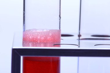 Stainless stand tutucu üzerinde Glass Tube Laboratuar araçları grubunda Bubble Red Liquid, Stüdyo aydınlatma beyaz arkaplan izole