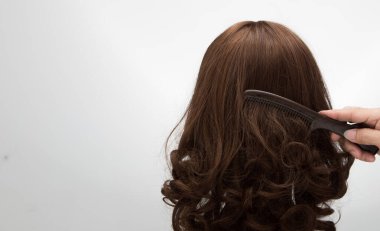 Rattan Head Manken standında yapay sahte saç peruğu, beyaz gri üzerinde izole edilmiş stüdyo ışıklandırması saç fotokopi alanı metin logosu, kahverengi kıvrım düz üst, profesyonel tarak pürüzsüz