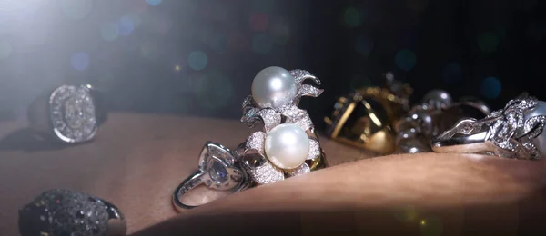 采购产品宝石 戴蒙德 金银珠宝 红宝石可漂白的戒指 把人的皮肤在黑暗的Bokeh背景与闪亮的物体 — 图库照片