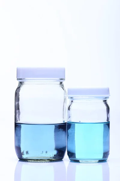Líquido Azul Grupo Dos Botellas Vidrio Tapa Blanca Estudio Iluminación —  Fotos de Stock