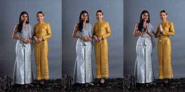 Tayland Geleneksel Kostümü ya da Güneydoğu Asya 'daki iki kız kardeş. Asya' lı Kadın Elbisesi Stüdyo 'nun gri arka planı ve kolaj grubu altında birçok pozlarda gülümsüyor.