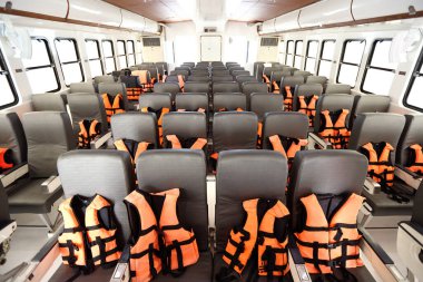 Turistlerin okyanus denizinde yüzmeleri için turuncu can yeleği olan lüks bir feribotta birçok koltuk kürek çekiyor ve önce yolculuk sırasında su altında şnorkelle yüzüyor.