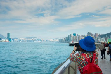 Kadının arkadan görünüşü, harika bir manzara olan Ocean Blue Sky Gölü 'nün manzarasını çekiyor. Büyük şehir binası, yaz tatilinde son durak olan uzay yürüyüşü sırasında.