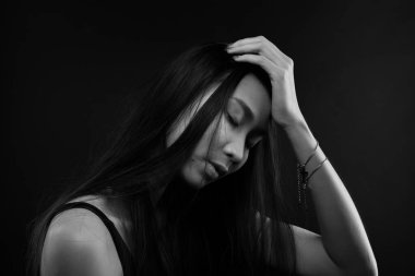 Sadece bronz tenli Asyalı kadın siyah düz saçlı arka plan, soyut düşük pozlama kontrast, metin logosu için fotokopi alanı, kırık kalp yalnız kız ağlayabilir.