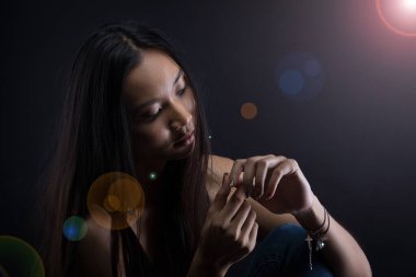 Sadece bronz tenli Asyalı kadın siyah düz saçlı arka plan, soyut düşük pozlama kontrast, metin logosu için fotokopi alanı, kırık kalp yalnız kız ağlayabilir.
