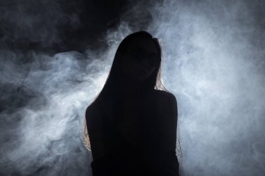 Beyaz dumanlı bronz tenli Asyalı kadın koyu arkaplanda yoğun kabarık tüylü sisli düz saçlı, soyut düşük pozlu kontrast, metin logosu için kopya alanı, kırık kalpli yalnız kız ağlayabilir.