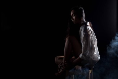 Beyaz dumanlı bronz tenli Asyalı kadın siyah düz saçlı, iş gömlekli, soyut düşük pozlama kontrast, metin logosu için fotokopi alanı, kırık kalp yalnız kız ağlayabilir