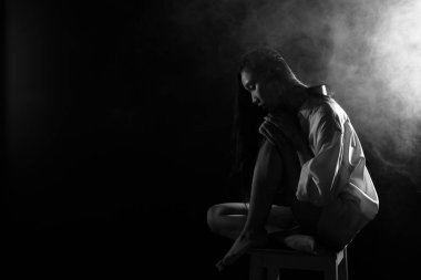 Beyaz dumanlı bronz tenli Asyalı kadın koyu arkaplanda yoğun kabarık tüylü sisli düz saçlı, soyut düşük pozlu kontrast, metin logosu için kopya alanı, kırık kalpli yalnız kız ağlayabilir.