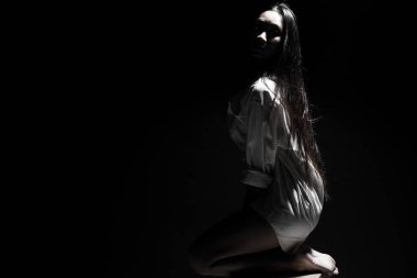 Beyaz dumanlı bronz tenli Asyalı kadın koyu arkaplanda yoğun kabarık tüylü sisli düz saçlı, soyut düşük pozlu kontrast, metin logosu için kopya alanı, kırık kalpli yalnız kız ağlayabilir.