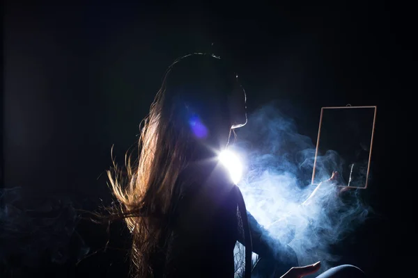 White Smoke Tan Skin Asian Woman black straight hair with mirror reflect herself face dark Background, Abstract high low exposure contrast, copy space for text logo, broken heart lonely girl can cry