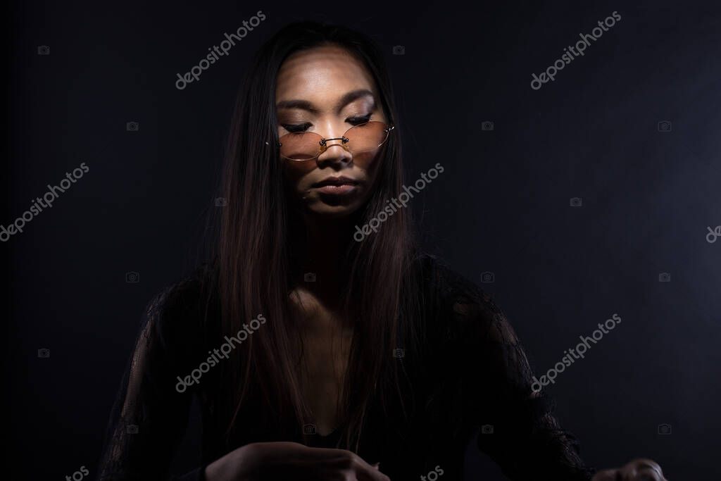 White Smoke Tan Skin Asian Woman black straight hair with Dense Fluffy Puffs of Fog on dark Background, Abstract high low exposure contrast, copy space for text logo, broken heart lonely girl can cry
