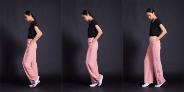 Güzel Asyalı 20 'li yaşlarda, esmer, zayıf tenli, siyah elbiseli, pembe pantolonlu, hareketli pozlar veren bir kadın. Tam vücut uzunluğu portresi izole edilmiş siyah arkaplan kopyalama alanı, kolaj grubu paketi