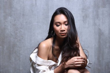 Güzel Asyalı Uzun düz siyah saçlı beyaz erkek gömlekli kadın, yüksek seksi moda makyaj yüz, konsept uyan sabah yatak odası tarzında