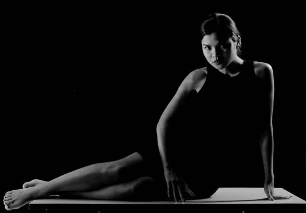 Donna Tenta Giocare Yoga Con Braccia Gambe Ginocchia Vestito Nero — Foto Stock