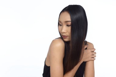 Genç Moda Model Kadın uzun kahverengi düz saçlı bir fikir gibi görünüyor ve metin reklamları için sol taraftaki fotokopi alanını işaret ediyor, Stüdyo Işıklandırma beyaz izole arka plan