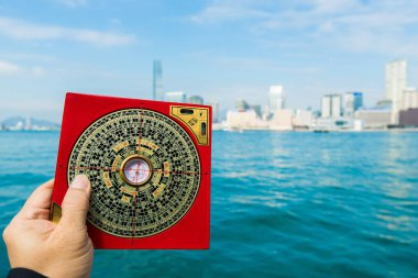 Feng Shui Ustası FengShui 'ye pusulayı göster ve Güç Enerjisi' ne yönlendir, Kuzey Batı 'da şans ve refah aramak için siyah gömlek giyer Rüzgâr Su elementleri üzerine Dizayn Binası İşaretleri