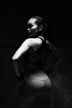 Asyalı bronz tenli spor kadın kollarını esneterek boks yapıyor. Arka planda, stüdyo aydınlatma gradyanı gri üst gölge düşük pozlama fotokopi alanı, konsept kadın 6 paket spor yapabilir.