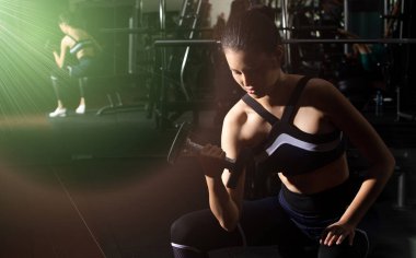 Asyalı ince spor kadın, siyah saçlı spor sütyen, vücut geliştiren halterci, Fit Gym 'de kol kası trisepsleriyle ısınıyor. Kadın sporcu sağlıklı sporcu olabilir.