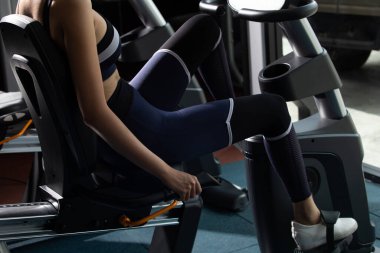 Spor salonunda spor bisikletli bisiklet itme makinesinde ısınan Asyalı zayıf spor kadın siyah saç sutyeni. Kavramsal kadın sporcu sıhhatli, yüzü yok.