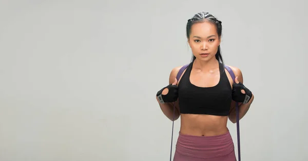 亚洲人皮肤健康女人运动热身伸展阻力带腹肌穿黑色运动胸罩桑树紫色裤子 工作室照明灰色背景复制空间 概念女人能做运动6包 — 图库照片