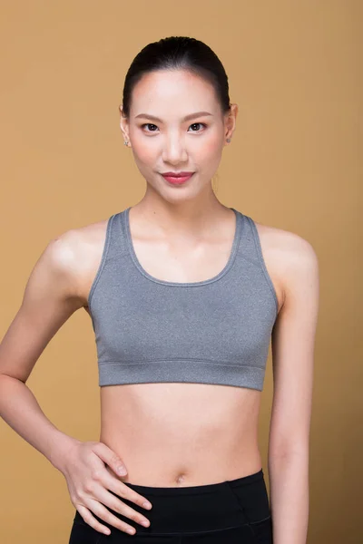 亚洲身材纤细的女子锻炼身体热身伸展胳膊腿 工作室点亮黄色米黄色芥末背景影印空间 概念女子可以做运动员运动6包 — 图库照片