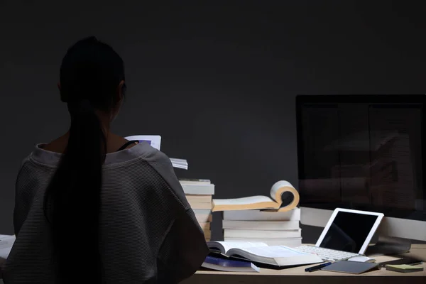 Asian Girl in white shirt reading many textbooks on table with many high stacking of international Books Journal Report, Woman works hard during night time, feel asleep tired, low exposure turn back