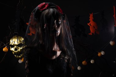 Kara Dul 'un peçesi, yüzü yeni örtünmüş. Yüzünde yeni bir yara izi var. Gölge şeklinde bir siluet.