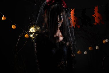 Kara Dul 'un peçesi, yüzü yeni örtünmüş. Yüzünde yeni bir yara izi var. Gölge şeklinde bir siluet.