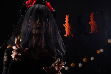 Kara Dul 'un peçesi, yüzü yeni örtünmüş. Yüzünde yeni bir yara izi var. Gölge şeklinde bir siluet.