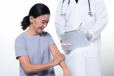 60 'lı yaşlardaki Asyalı Kadın Hasta Doktor' la sağlık kontrolü yapıyor. Yaşlanan Toplum Kadınları Sağlık Hizmetleri Teşhisi Ofis Sendromu sırt ağrısı, tıbbi uzmanlık, stüdyo ışıklandırması izole edilmiş kopya alanı