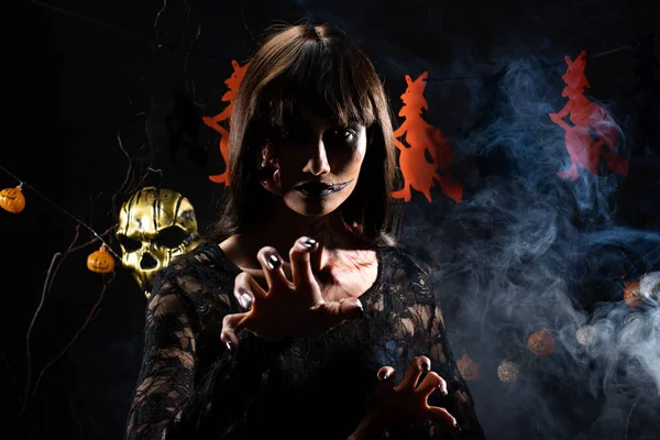 Cadılar Bayramı geçmişinde cadı ve balkabağı çelengi asılı, Yüzünde taze yara olan hayalet zombi kız Yüzünde siyah saç elbisesi korkunç ve tüm perili yerleri öldürmek istiyor