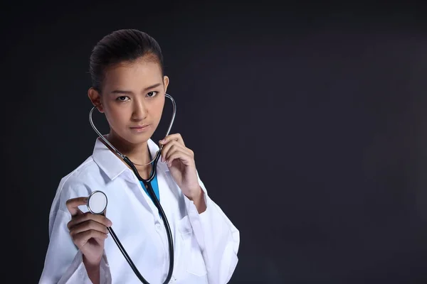 アジアの美しい医師の女性で制服で聴診器チェック行為 肖像画の半分の体は黒ラップ髪を構成します スタジオ照明グレー黒暗いです背景コピースペース — ストック写真