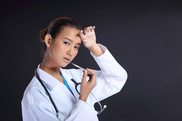 アジアの美しい医師の女性で制服で聴診器 体温計は体内の熱をチェック 肖像画の半分の体は黒を構成します スタジオ照明グレー黒黒暗いです背景コピースペース — ストック写真