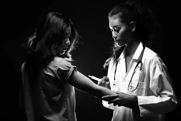 청진기를 아시아인아름다운 간호사가 관리를 치료하기 환자에게 비타민 주사기를 주사하고 스튜디오에서는 — 스톡 사진