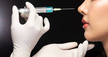 Güzellik Uzmanı Estetik Cerrahi Doktor Hemşire Genç Hasta Burun 'a güzel bir serum enjekte ediyor. Stüdyo Işıklandırma gradyan Karanlık Arkaplan ışıklandırması
