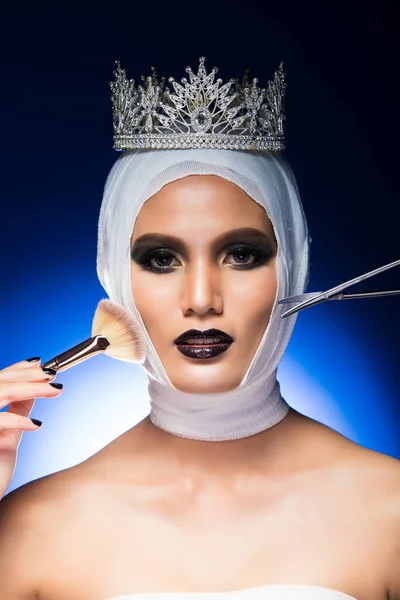 Aesthetic Miss Beauty Pageant Contest Diamond Crown was checked diagnose test by Nurse Doctor hand with medical scissors equipment and cosmetic brush. Studio Lighting gradient Blue Background