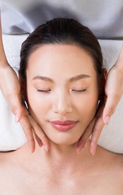 Yüz masajı için Ayurvedic baş masajı Asyalı kadının ana çakra noktası, terapist kaplıca kadın müşteriye tedavisini sunuyor.