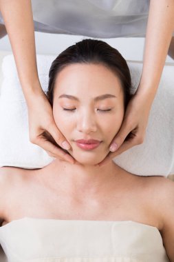 Yüz masajı için Ayurvedic baş masajı Asyalı kadının ana çakra noktası, terapist kaplıca kadın müşteriye tedavisini sunuyor.
