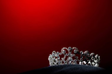 Silver Diamond Crown of Miss Pageant Beauty Universe World Contest sparkle light on black pillow, ready for wear Most beautiful Winner, studio lighting super red gradient background dramatic clipart
