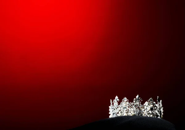 ミスペガント美の世界コンテストのシルバーダイヤモンドクラウン黒枕の上に輝く光 着用する準備ができて最も美しい勝者 スタジオ照明超赤グラデーション背景劇的な — ストック写真