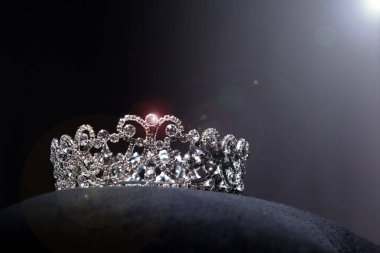 Diamond Silver Crown for Miss Pageant Beauty Contest, Crystal Tiara jewelry decorated gems stone and abstract dark background on black velvet fabric cloth, Macro photography copy space for text logo