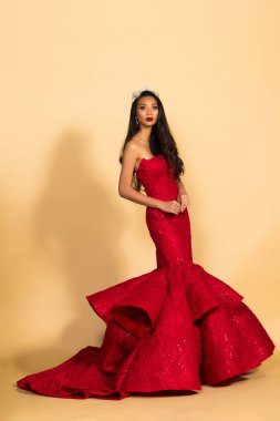 Asya Güzellik Yarışması Kraliçesi. Gece Balosu elbisesi, elmas taç kuşağı, makyaj, yüz makyajı, kalp saç stili, stüdyo ışıklandırması bej arka plan izole edilmiş kopya alanı.