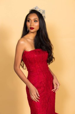 Asya Güzellik Yarışması Kraliçesi. Gece Balosu elbisesi, elmas taç kuşağı, makyaj, yüz makyajı, kalp saç stili, stüdyo ışıklandırması bej arka plan izole edilmiş kopya alanı.