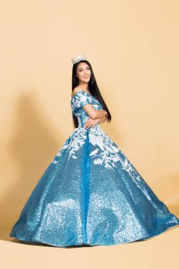 Asya Güzellik Yarışması Kraliçesi. Gece Balosu elbisesi, elmas taç kuşağı, makyaj, yüz makyajı, kalp saç stili, stüdyo ışıklandırması bej arka plan izole edilmiş kopya alanı.