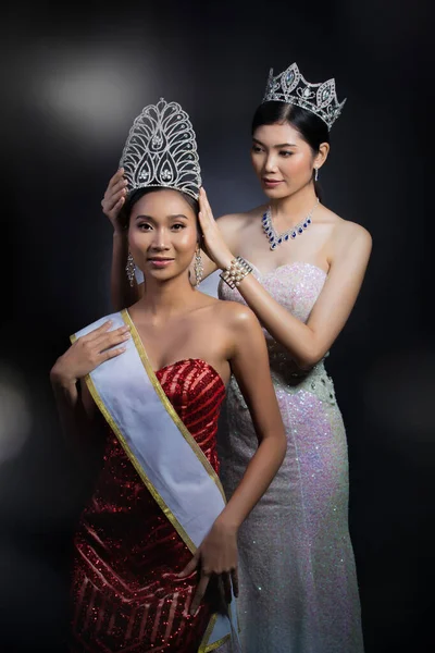 Last year winner Miss Beauty Pageant Contest put Diamond Crown on Final Winner latest year Miss Beauty Queen Pageant Contest with feeling wow smile glad face expression, two asian women moment session