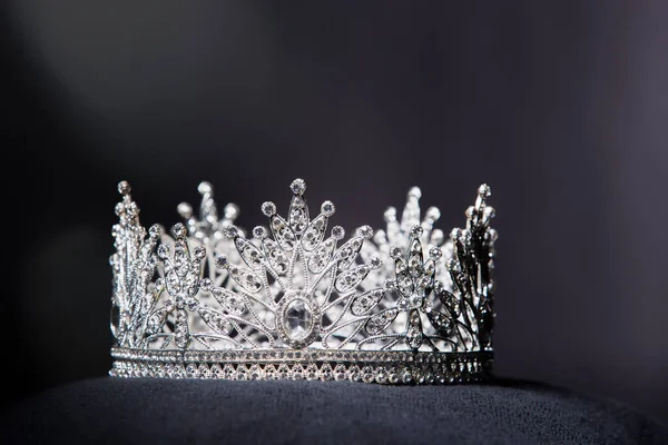 Diamond Silver Crown for Miss Pageant Beauty Contest, Crystal Tiara jewelry decorated gems stone and abstract dark background on black velvet fabric cloth, Macro photography copy space for text logo