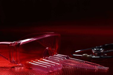Science Medical R & D, dropper, goggle, stethoscope, Glass Tube Lab Test tools, Studio lighting reddish background copy space, red tone concept
