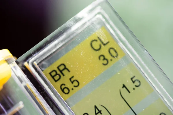 关闭Ph测试仪的水平栏 显示数量指标 呈现黄色和紫色阴影 宏观摄影和模糊效果 低曝光度 — 图库照片